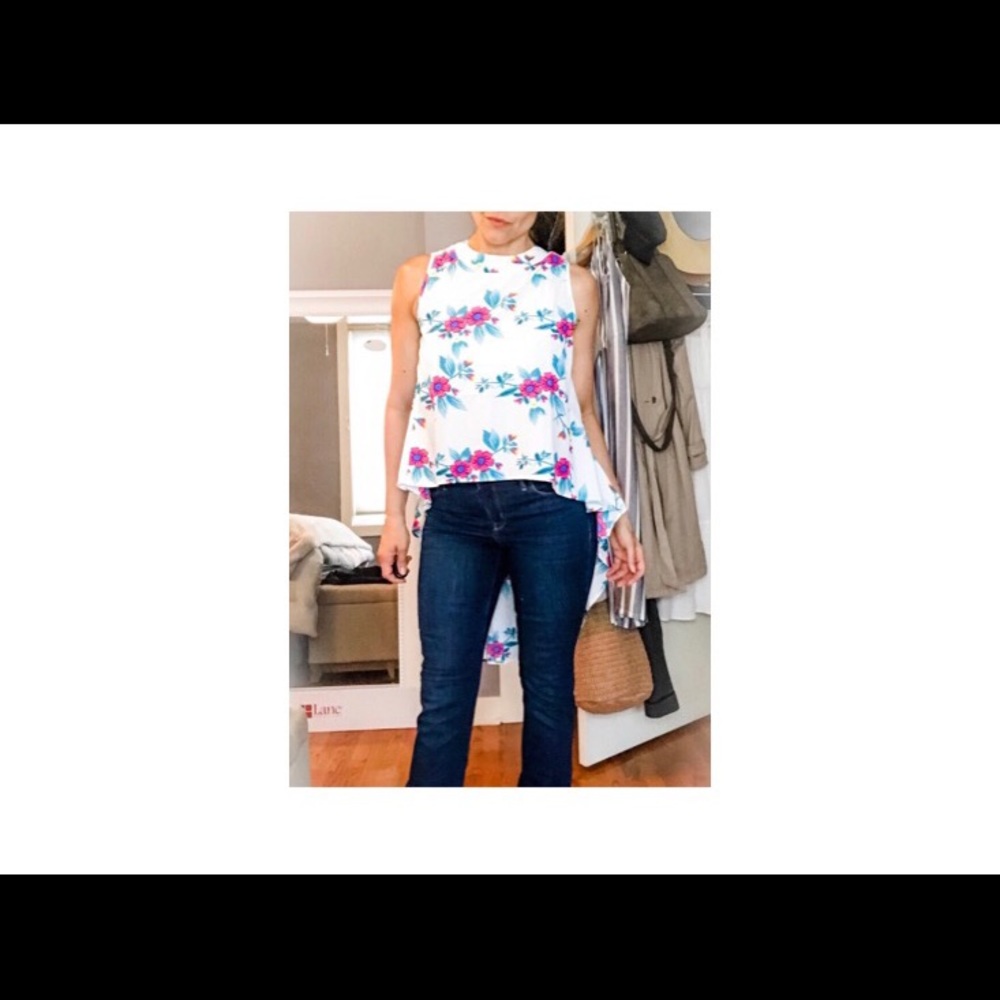 Sleeveless flowered printed blouse with long back.